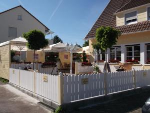 una cerca blanca frente a una casa en Gasthaus Vogelgarten, en Eislingen