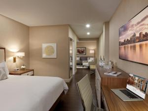 ein Hotelzimmer mit einem Bett und einem Schreibtisch mit einem Laptop in der Unterkunft The Lord Nelson Hotel & Suites in Halifax