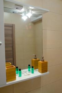 ママイアにあるBliss by Lex Apartmentsのバスルーム(鏡、白い棚、ボトル付)