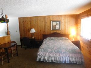 a bedroom with a bed and a desk and a table at The Tamarack Lodge in Lakeshore