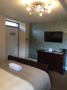 a bedroom with a bed and a flat screen tv at The Ship Inn in Invergordon