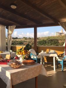 una mesa con un plato de comida en el balcón en B&B Il Tramonto, en Castelsardo