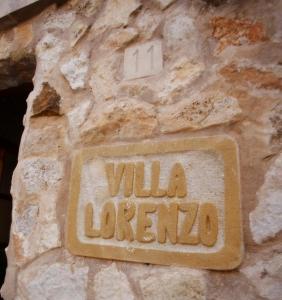 a sign on the side of a stone wall at Villa Lorenzo in Cala Figuera