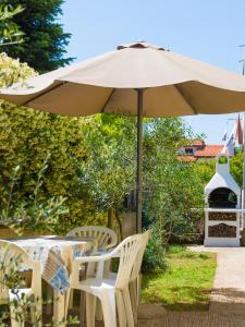 a table and chairs under an umbrella at Apartments Manuela in Pula