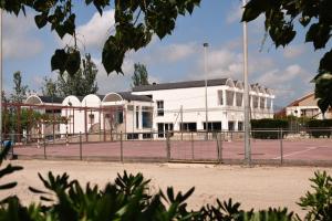 a tennis court in front of a white building at Alberg Deltebre Xanascat in Deltebre