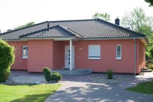 uma casa com uma casa vermelha em H24ZINGST - Das Ferienhaus em Zingst
