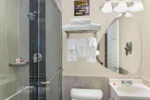 a bathroom with a sink toilet and a mirror at Ramada by Wyndham Miami Springs/Miami International Airport in Miami