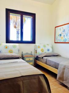 プルサーノにあるVilla Lido Silvana Marina di Pulsanoのベッドルーム1室(ベッド2台、窓付)