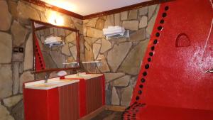 a bathroom with two sinks and a stone wall at Le Bambou Gorilla Lodge in Ruhengeri +66 photos