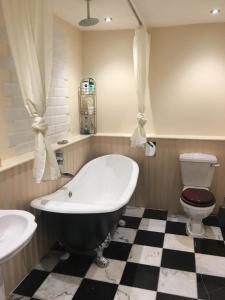 a bathroom with a bath tub and a toilet at The Ship Inn in Invergordon