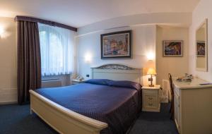 ein Schlafzimmer mit einem blauen Bett und einem Fenster in der Unterkunft Villa San Giorgio in SantʼAmbrogio di Valpolicella