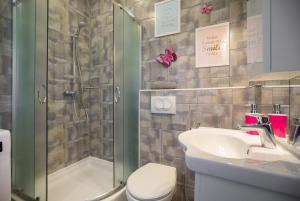 um banheiro com chuveiro, pia e vaso sanitário em Apartman Pierre em Zagreb