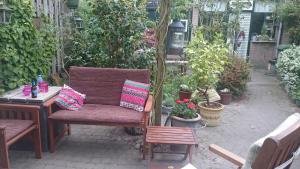a patio with a chair and a table and plants at B&B Aan het Park Eindhoven in Eindhoven