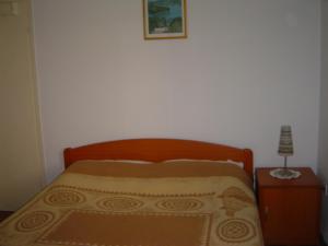 sypialnia z łóżkiem z drewnianym zagłówkiem i stołem w obiekcie Villa Mandarina w miejscowości Mali Lošinj