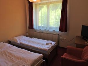 A bed or beds in a room at Penzion Montana