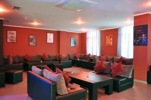 una sala de espera con paredes rojas y sofás en Hotel Shine Palace en Tiflis