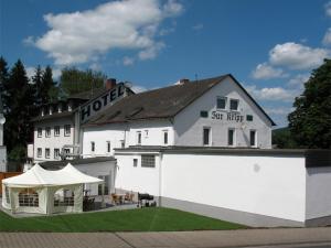ein weißes Gebäude mit einem Zelt davor in der Unterkunft Hotel Zur Kripp in Koblenz