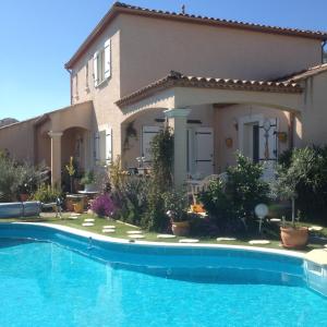 a house with a swimming pool in front of it at Chez Patrick Roujan in Roujan