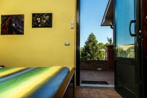 ポルト・サン・ジョルジョにあるAgriturismo B&B Le Gazzeのベッド1台とガラスのスライドドアが備わる客室です。