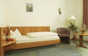1 dormitorio con cama, escritorio y silla en Hotel Rossner en Münchberg