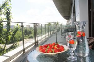 talerz truskawek na stole na balkonie w obiekcie Apart Studio Warszawa w Warszawie
