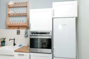een keuken met witte kasten en een koelkast bij Sea Crib Apartment in Varna