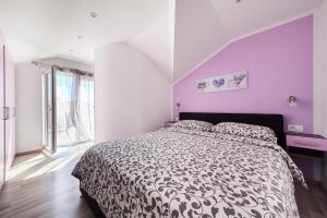 um quarto com uma cama e uma parede roxa em Apartment Tamara em Umag