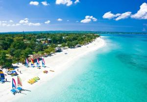 an aerial view of a beach with chairs and water at Beaches Negril Resort and Spa - All Inclusive in Negril