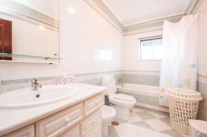 a bathroom with a sink and a toilet and a tub at Rivers Nation Surf Camp in Atouguia da Baleia +49 photos
