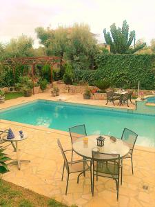 a patio with tables and chairs next to a pool at Jacuzzi Pool House AMA5690 in Chalkida