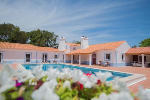 a villa with a swimming pool and two houses at O Monte das Flores in Vila Nova de Milfontes