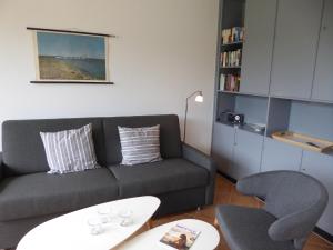 sala de estar con sofá, mesa y sillas en Ferienhaus Rücker, en Fehmarn