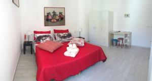 a bedroom with a red bed with two teddy bears on it at B&B MaryGrace in Alghero