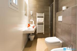 a bathroom with a white toilet and a sink at Hotel Amicizia in Rimini