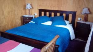 a bedroom with a blue bed with two night stands at Villa Rosa House in Pinto
