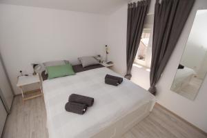 - une chambre dotée d'un grand lit blanc avec deux sacs dans l'établissement Apartment Smokva ****, à Podgreben