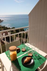 - une table avec de la nourriture et des verres sur un balcon donnant sur l'océan dans l'établissement Apartment Smokva ****, à Podgreben