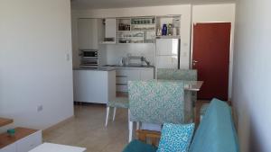 uma cozinha com uma mesa e cadeiras e um frigorífico em Tu Hogar en Neuquen em Neuquén