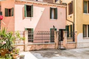 a pink building with a gate in front of it at Serenissima in Venice