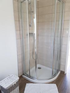 y baño con ducha y puerta de cristal. en villa donia en Corte