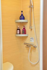 a bathroom with a shower with two shelves on the wall at Comfortable House In Fushimi in Kyoto