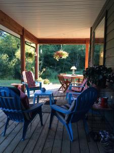 a porch with two chairs and a table and a table at Salmon Point B&B in Oyster Bay