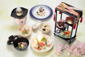 a table with plates of food and a doll house at Izumiya Ryokan in Kyoto