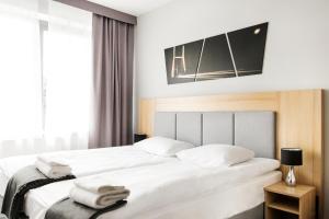 two beds in a hotel room with white sheets at Waw Hotel Airport Okęcie in Warsaw
