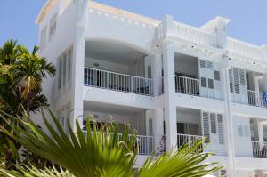 een wit gebouw met palmbomen ervoor bij 3123 BEACH CLUB PARADISE in Palm Cove
