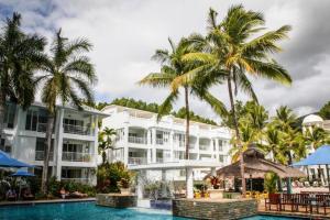 a resort with a swimming pool and palm trees at 3121 "SHILOH" AT THE BEACH CLUB in Palm Cove