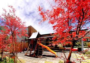 a tree with red leaves in front of a building at Winlu Vacation Farm in Renai