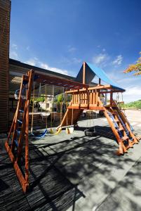 un parque infantil de madera con un tobogán en un edificio en Winlu Vacation Farm, en Renai