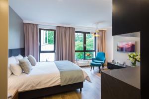 a hotel room with a bed and a blue chair at 7 Heaven - Victoria Residence by OneApartments in Sopot