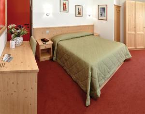 Un dormitorio con una cama verde y un escritorio de madera. en La Rotonda, en Pergine Valsugana